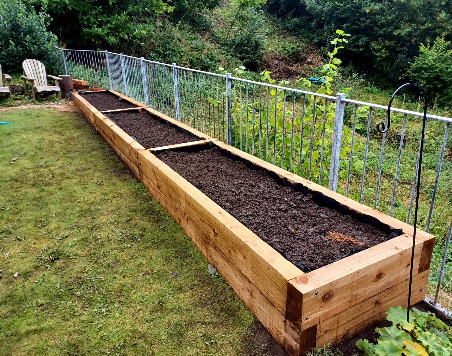 Long timber sleeper raised beds filled with soil